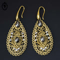 Chic paire de boucles d’oreilles percées pendantes arabesques dorées strass gris