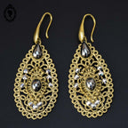 Chic paire de boucles d’oreilles percées pendantes arabesques dorées strass gris