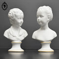 Deux statues bustes sur pied fille garçon en biscuit Tharaud Limoges blanc et doré