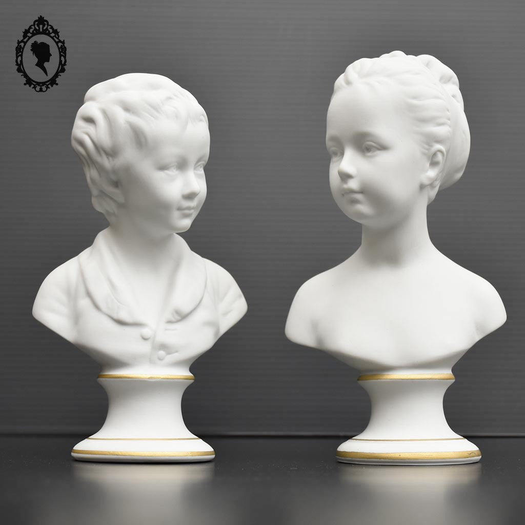 Deux statues bustes sur pied fille garçon en biscuit Tharaud Limoges blanc et doré