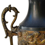 Paire de cassolettes décoratives à anses ornées et décors de putti, régule patine verte et dorée