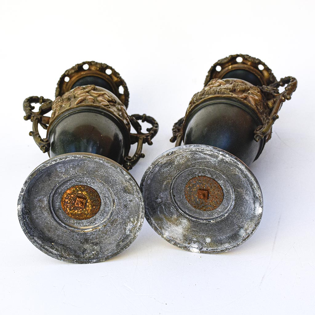Paire de cassolettes décoratives à anses ornées et décors de putti, régule patine verte et dorée
