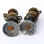 Paire de cassolettes décoratives à anses ornées et décors de putti, régule patine verte et dorée