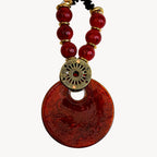 Collier style Murano rouge et doré, pendentif rond et perles noires rocailles